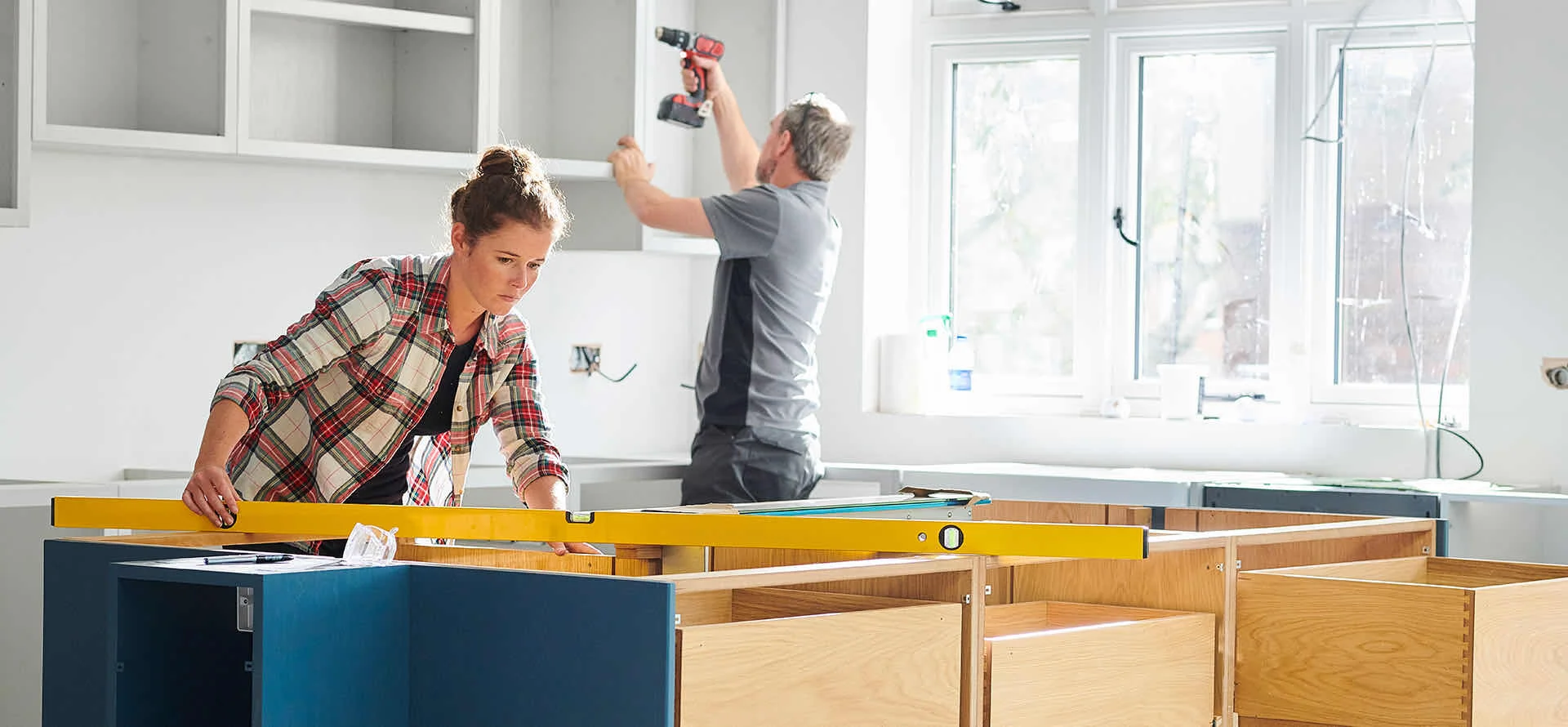 Couple installing kitchen cabinets