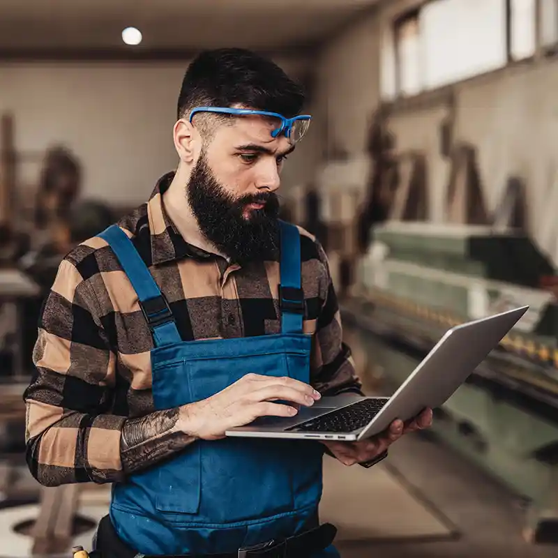 Man with beard checking finances on laptop in business
