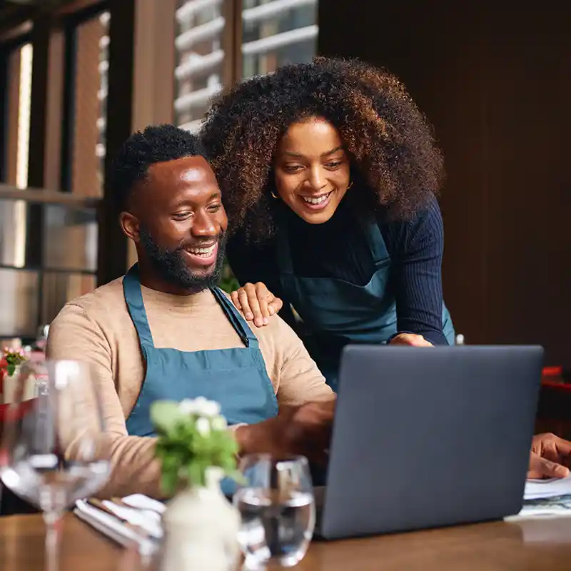 Couple smiling looking at finances online
