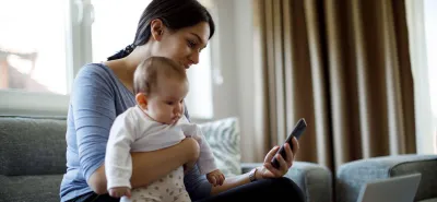 Woman with baby looking at cell phone