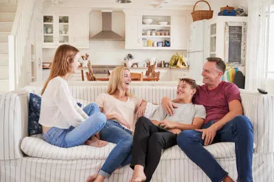 Family laughing together on couch.