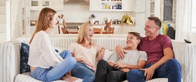 Family laughing together on couch.