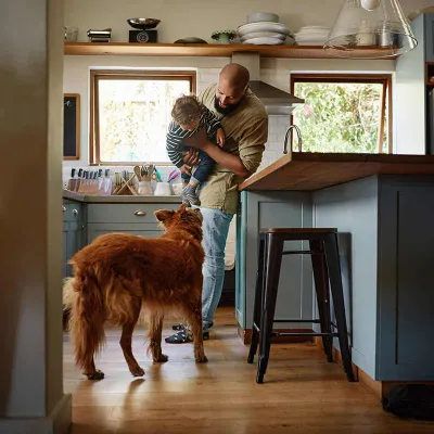 Man in kitchen with dog and son