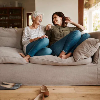 Mother and daughter on couch laughing