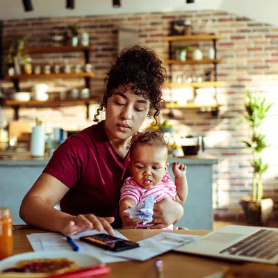 Woman paying bills holding baby